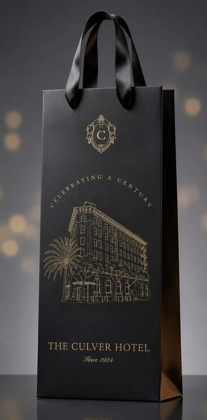A black and gold personalized Champagne bag for The Culver Hotel, gold-foiled with the hotel's crest and facade